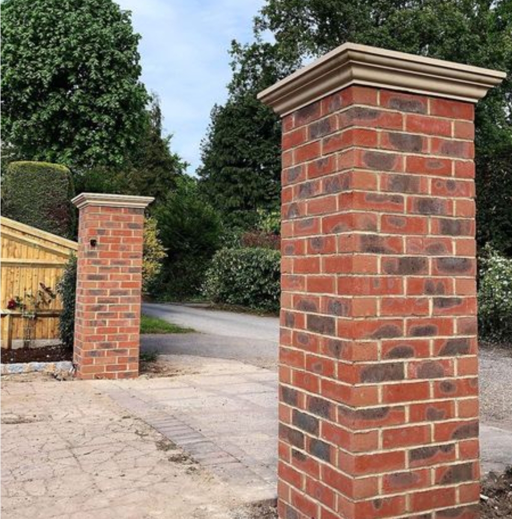 Brick entrance pillars with coping stones at driveway