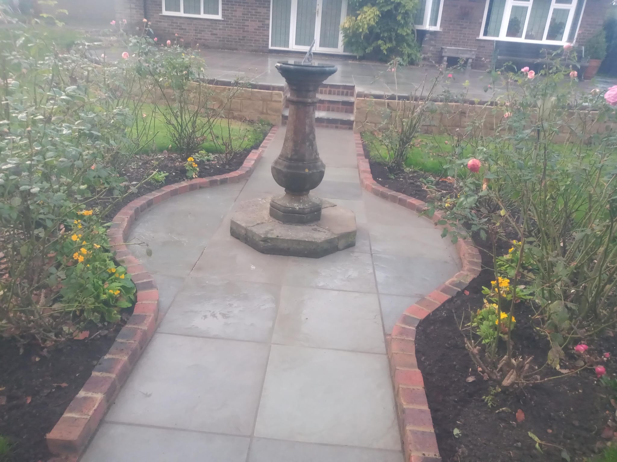 Curved patio pathway with decorative fountain centerpiece