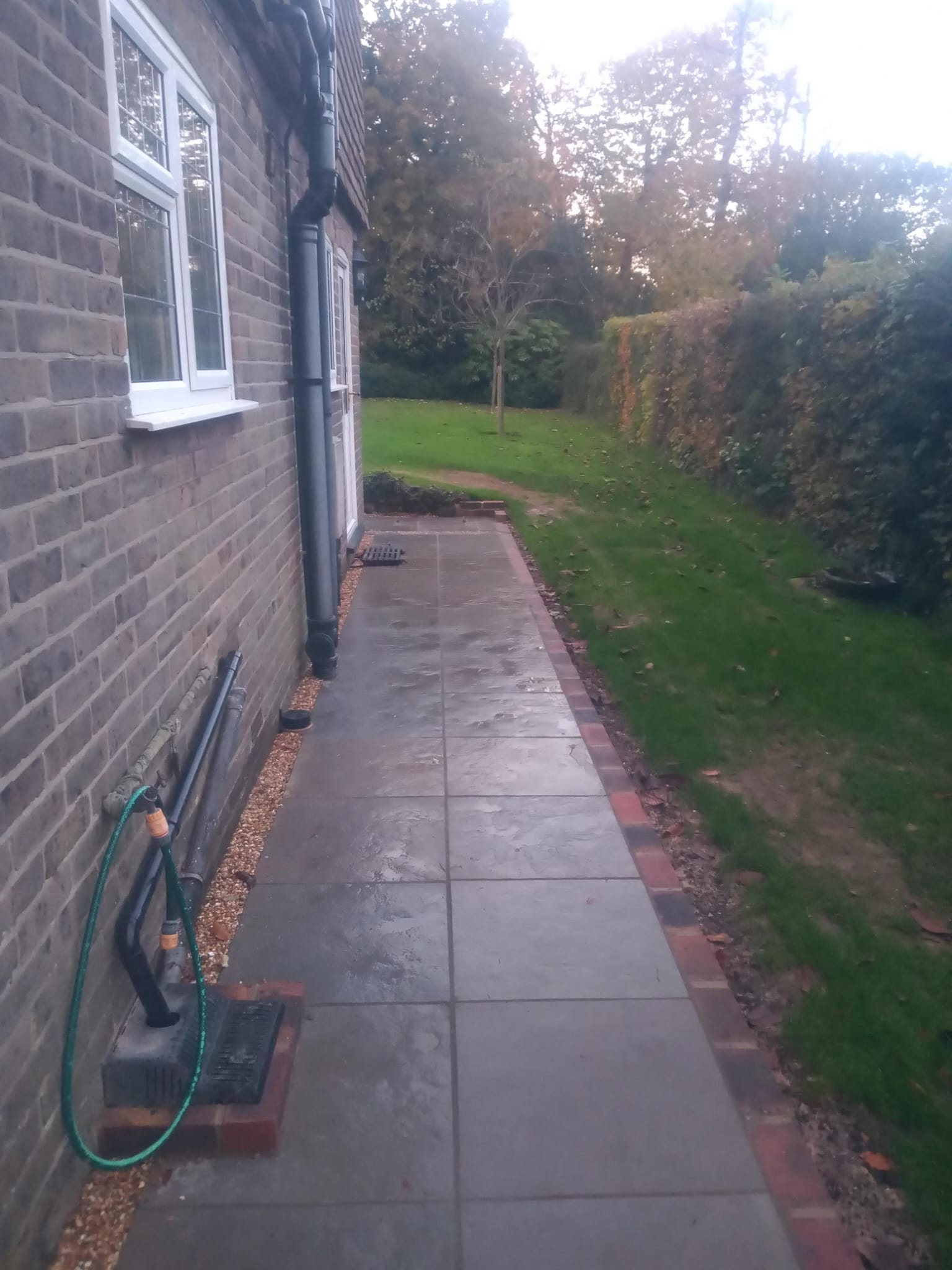 Side pathway with porcelain paving and brick edging