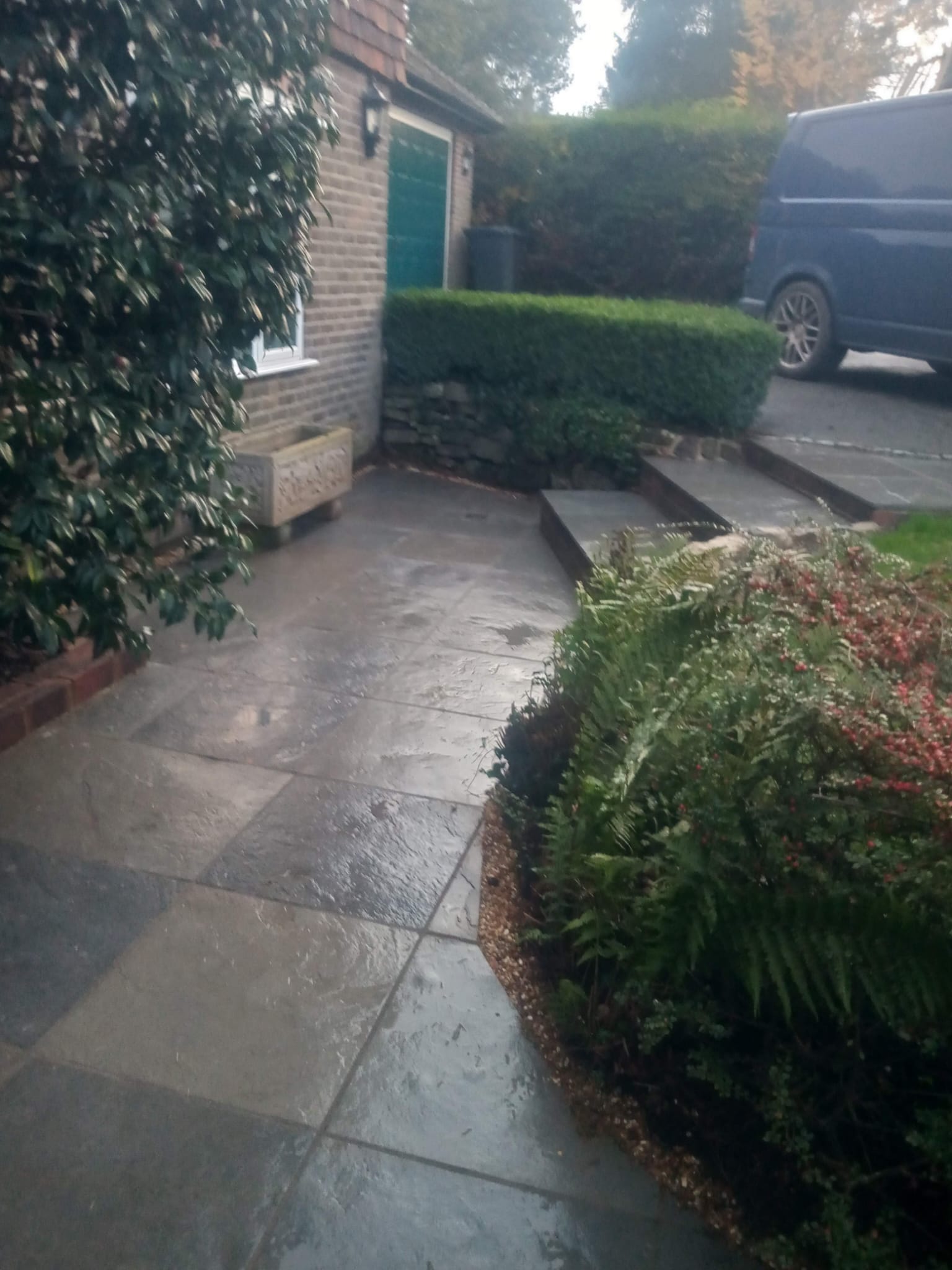 Slate patio and steps at front entrance with planted borders
