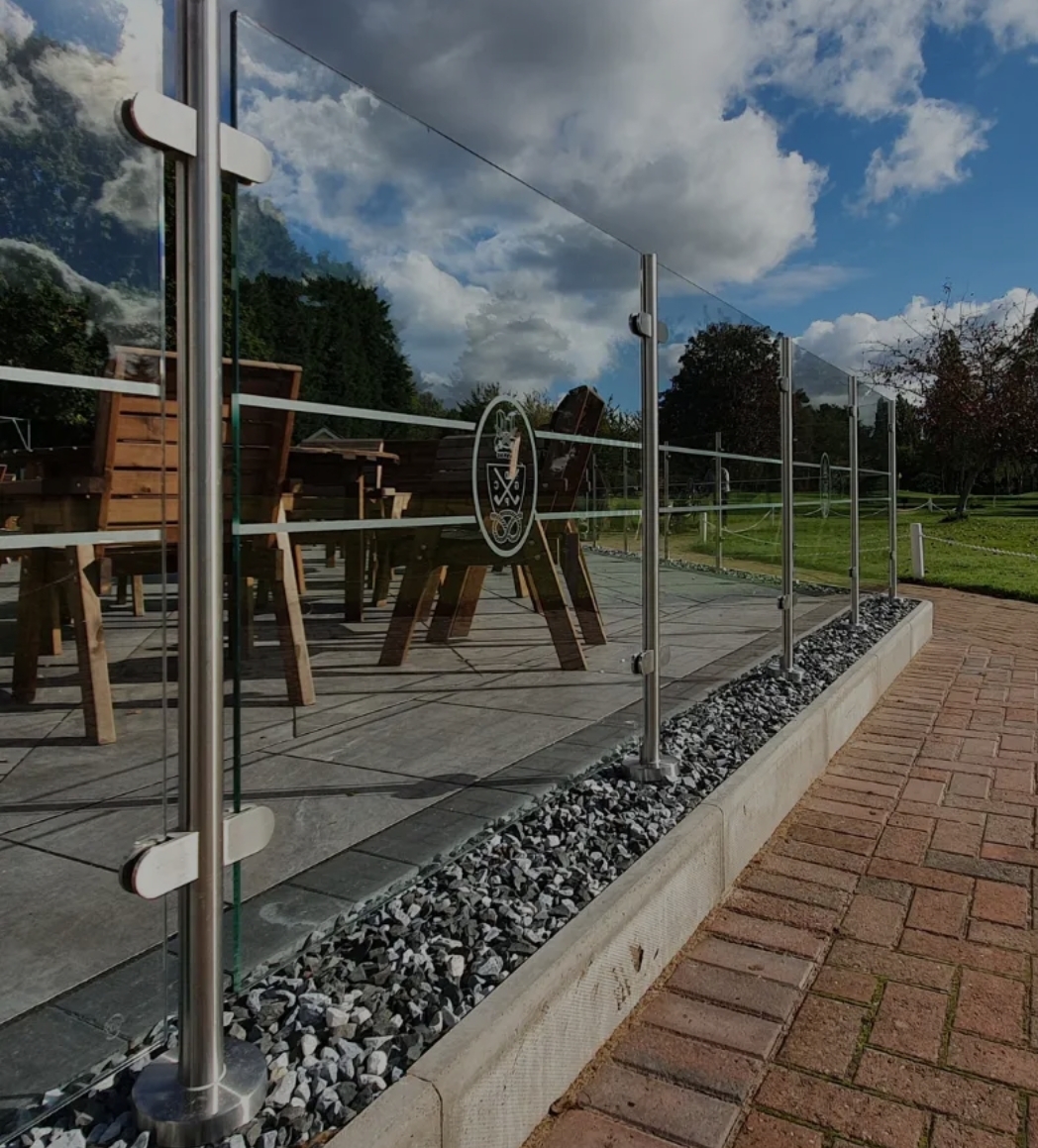 Glass balustrade with block paving and slate patio area
