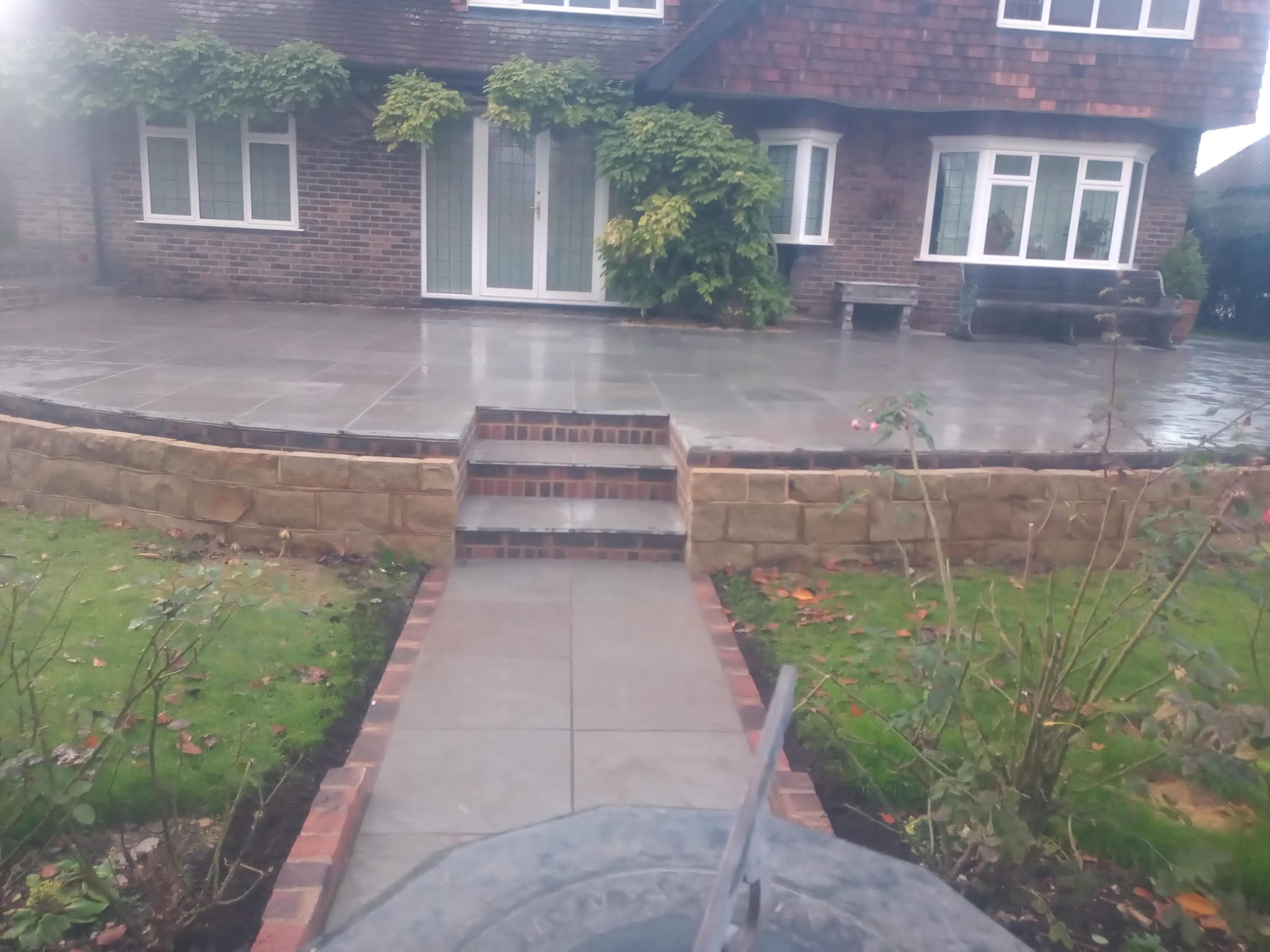 Stone patio with brick steps and natural stone retaining wall