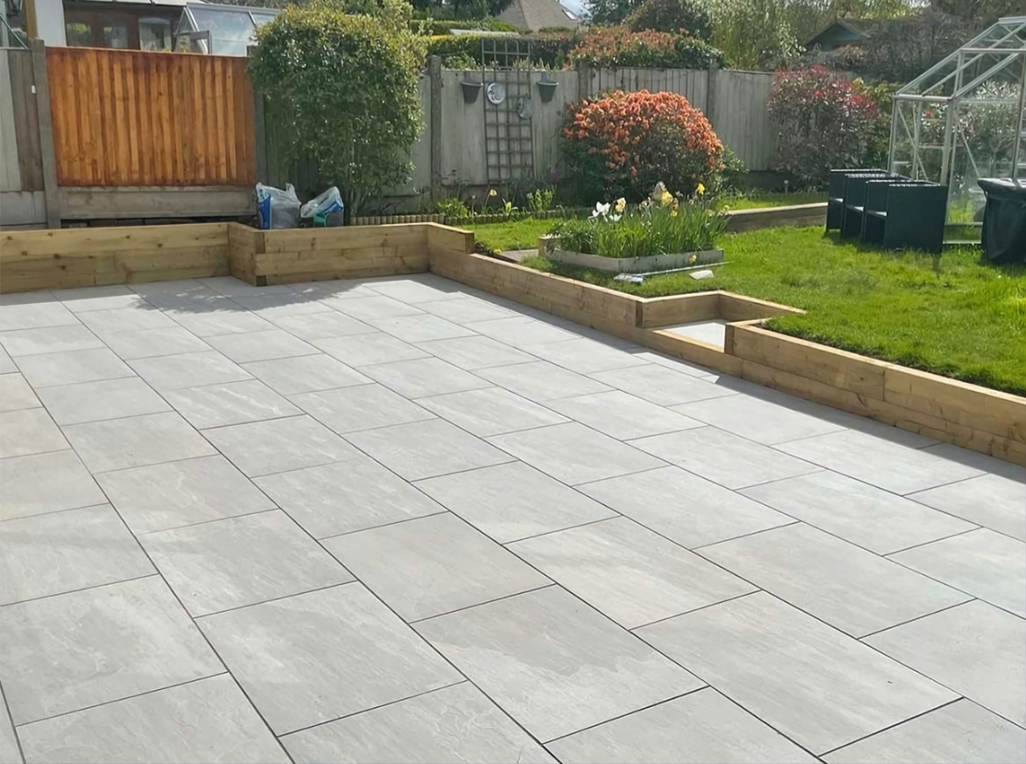 Light porcelain patio with timber sleeper edging