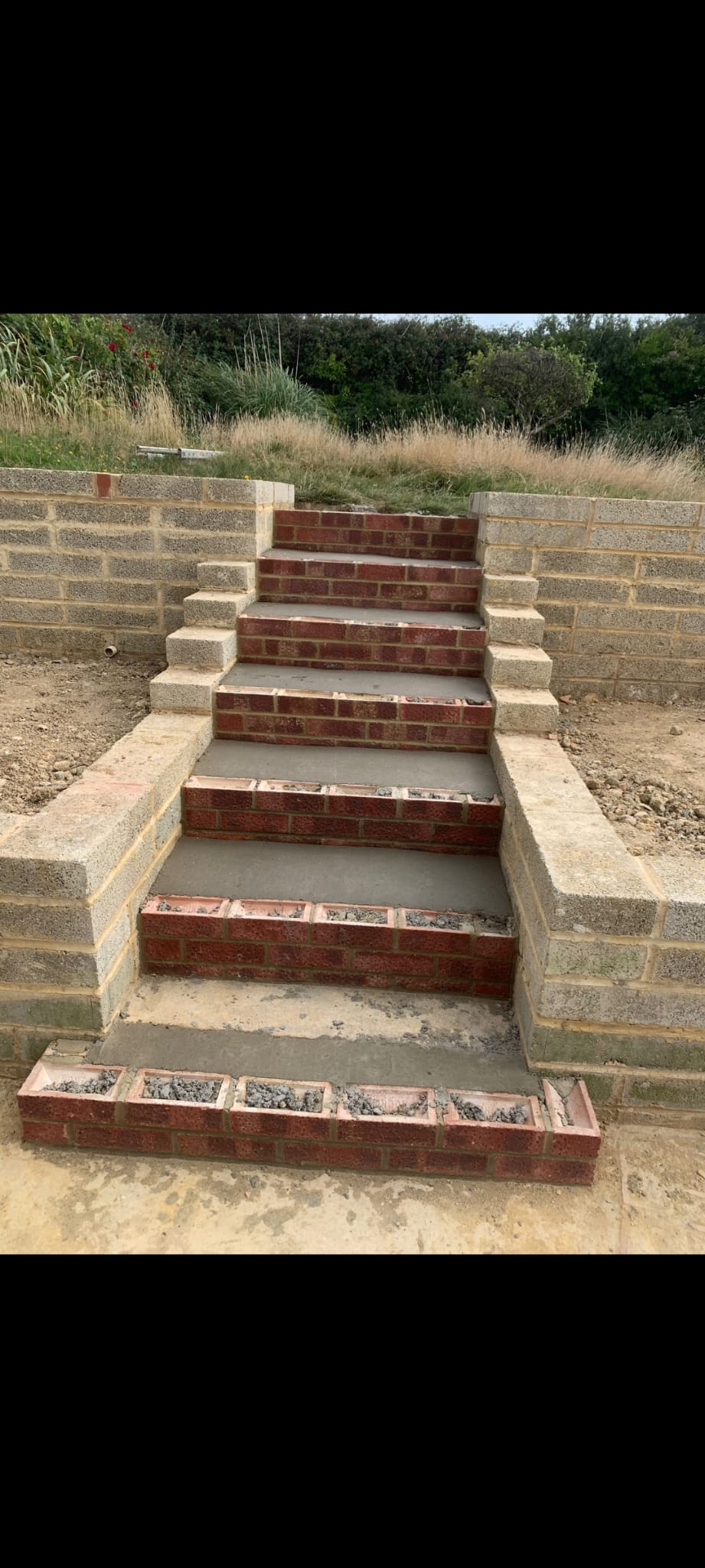 Brick steps under construction with block retaining walls