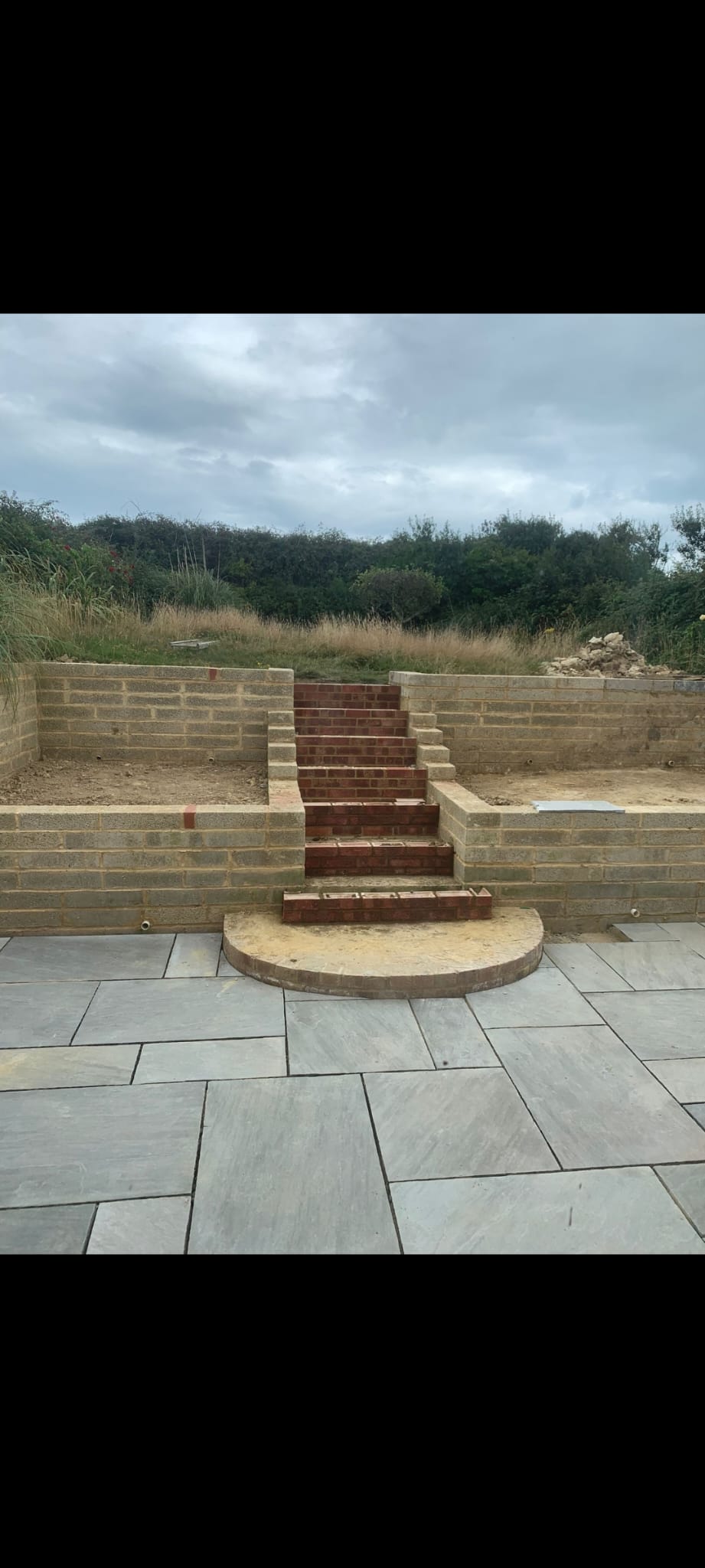 Tiered brick steps with retaining walls and slate patio